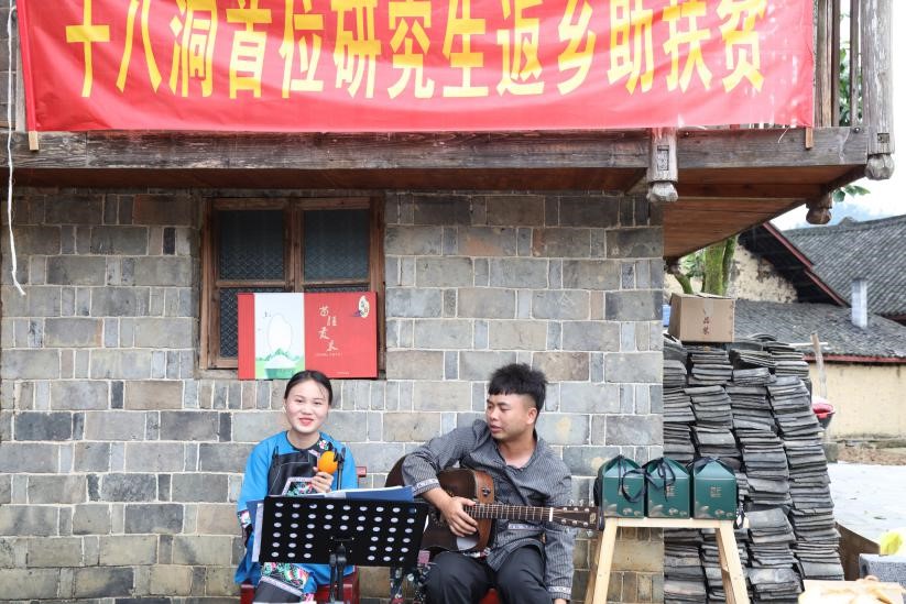 (图为 研究生施志春和当地阿妹弹唱现场)